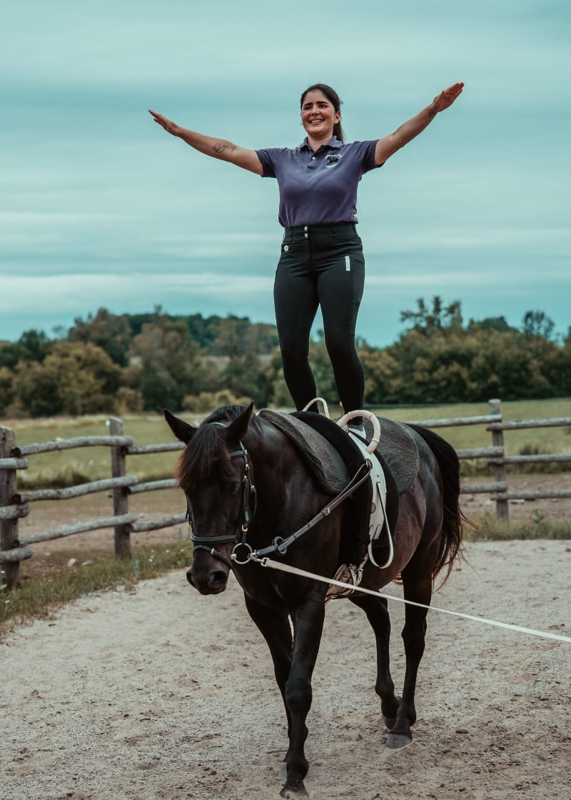 White Forest Farm vaulting coach Laila Ceballos Jung demonstrates her skills atop a black horse at White Forest Farm.