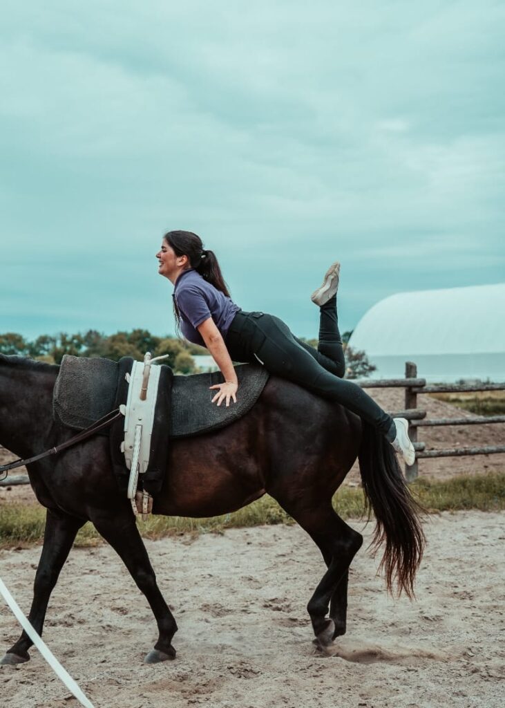 White Forest Farm vaulting coach Laila Ceballos Jung demonstrates her skills atop a black and white horse at White Forest Farm.