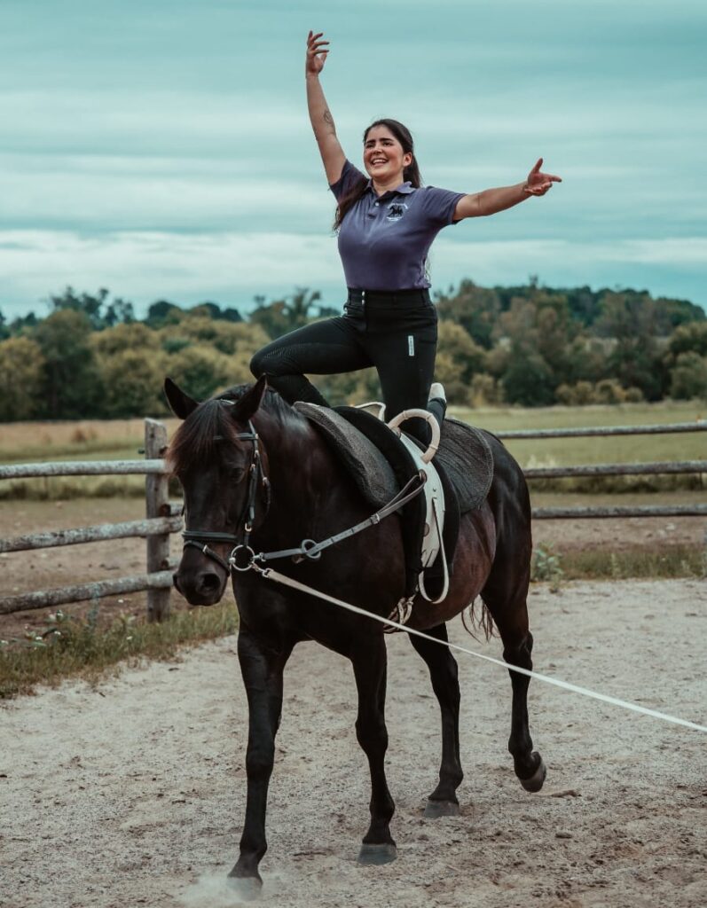 White Forest Farm vaulting coach Laila Ceballos Jung demonstrates her skills atop a black and white horse at White Forest Farm.