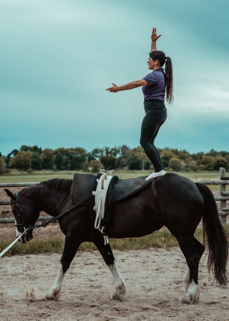 White Forest Farm vaulting coach Laila Ceballos Jung demonstrates her skills atop a black and white horse at White Forest Farm.